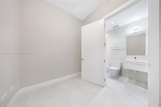 bathroom featuring toilet and vaulted ceiling