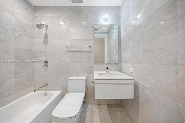 full bathroom with vanity, shower / washtub combination, toilet, and tile walls