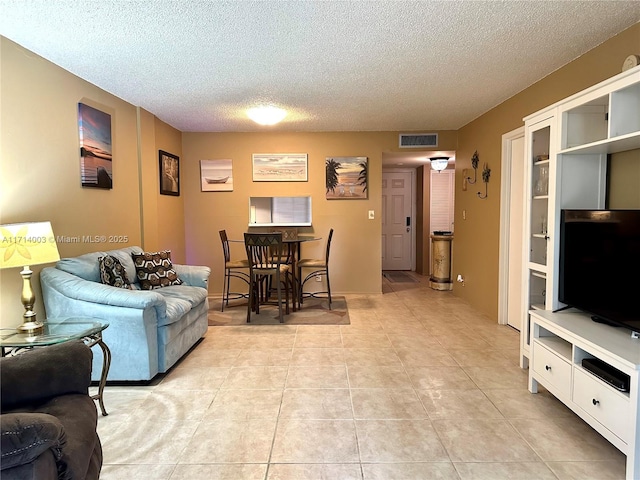 tiled living room featuring a textured ceiling