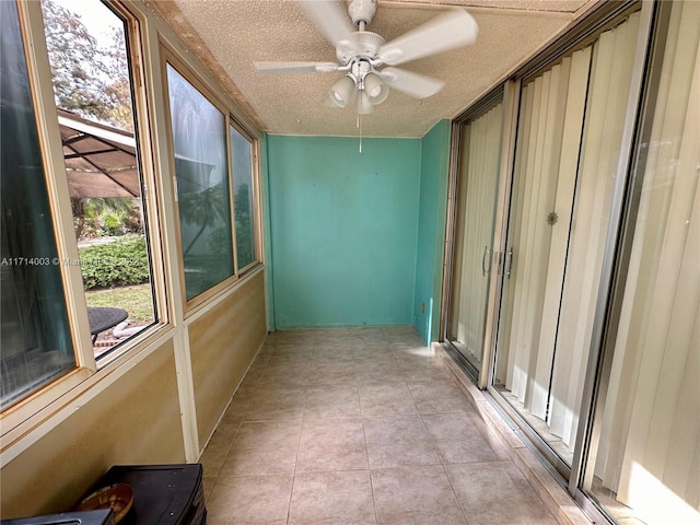 unfurnished sunroom with ceiling fan