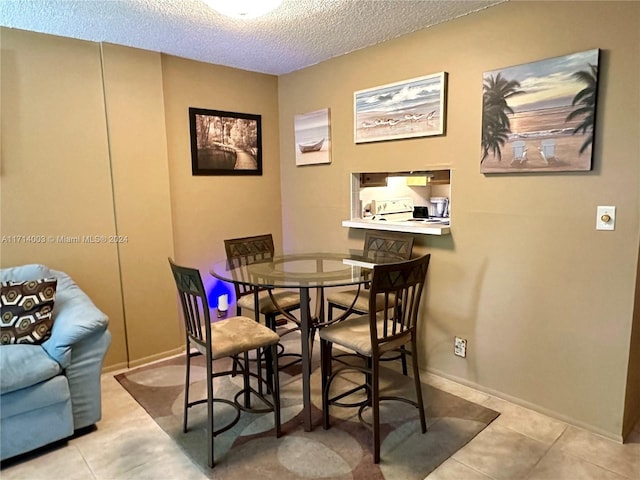 tiled dining space with a textured ceiling