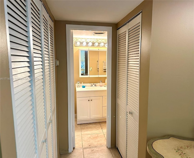 hall with light tile patterned flooring and sink