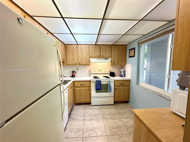 kitchen featuring tasteful backsplash, light tile patterned floors, and white appliances