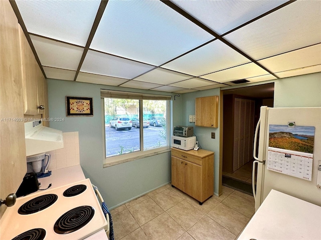 kitchen featuring white appliances, ventilation hood, and light tile patterned flooring