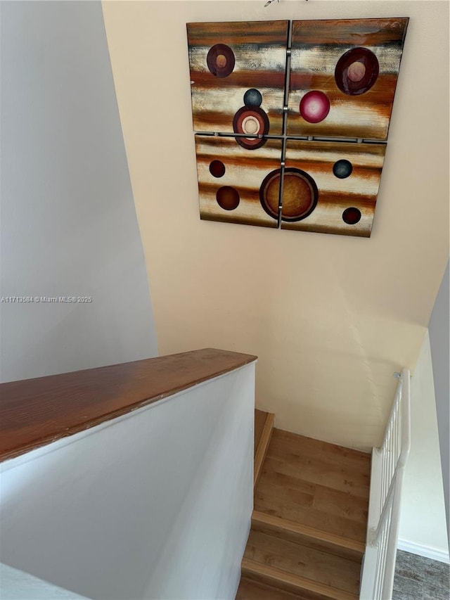 staircase featuring hardwood / wood-style flooring and log walls