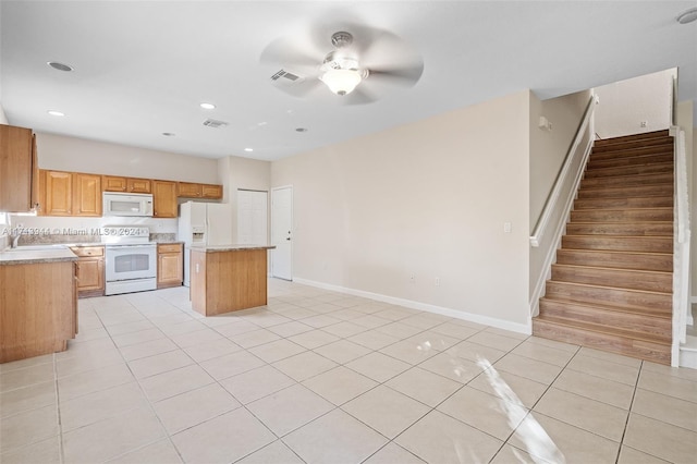 kitchen with ceiling fan, sink, a kitchen island, white appliances, and light tile patterned floors