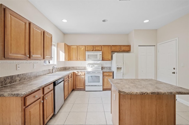 kitchen featuring sink, a kitchen island, white appliances, and light tile patterned floors