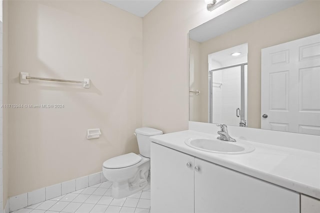 bathroom with tile patterned flooring, vanity, a shower with door, and toilet