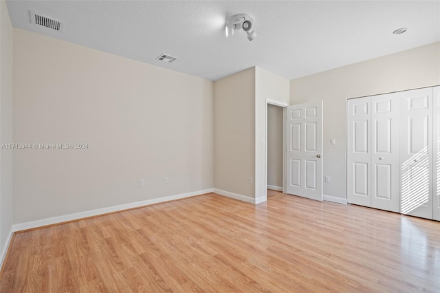 unfurnished bedroom featuring light hardwood / wood-style floors and a closet