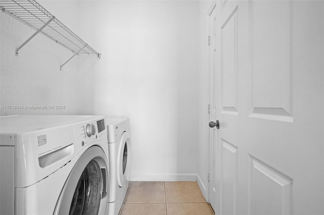 laundry area featuring washer and clothes dryer and light tile patterned floors