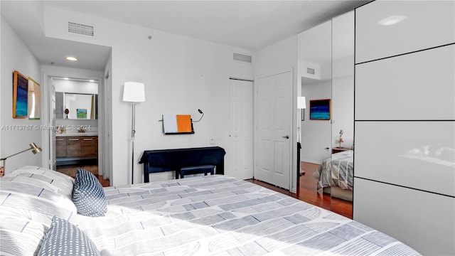 bedroom featuring wood-type flooring and ensuite bath