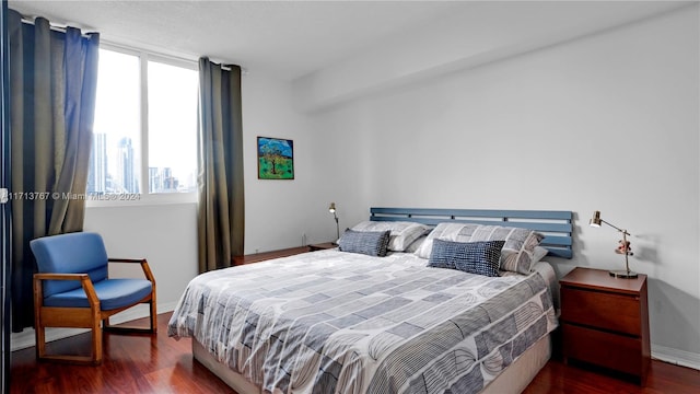 bedroom with dark hardwood / wood-style flooring