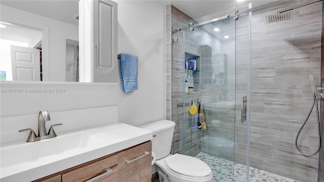 bathroom with walk in shower, vanity, and toilet