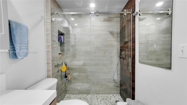 bathroom with vanity, toilet, and a shower with shower door