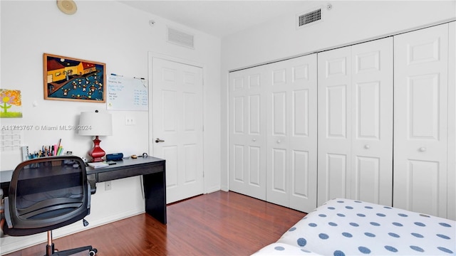 bedroom featuring dark hardwood / wood-style flooring and a closet