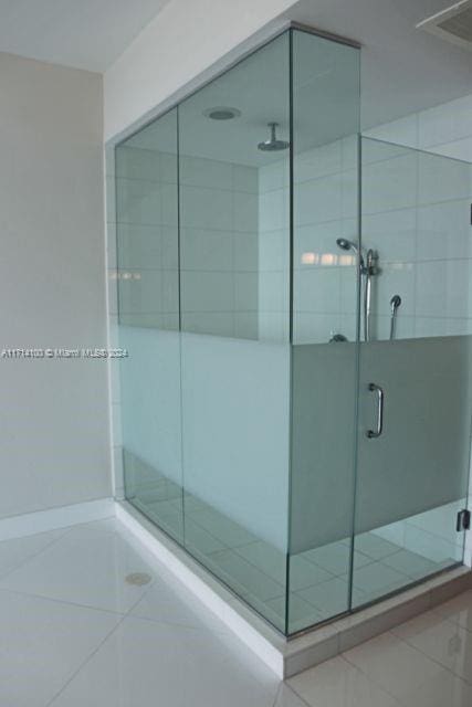 bathroom featuring tile patterned flooring and an enclosed shower