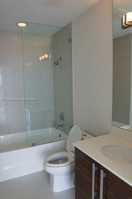 full bathroom with tile patterned floors, tiled shower / bath combo, toilet, and vanity