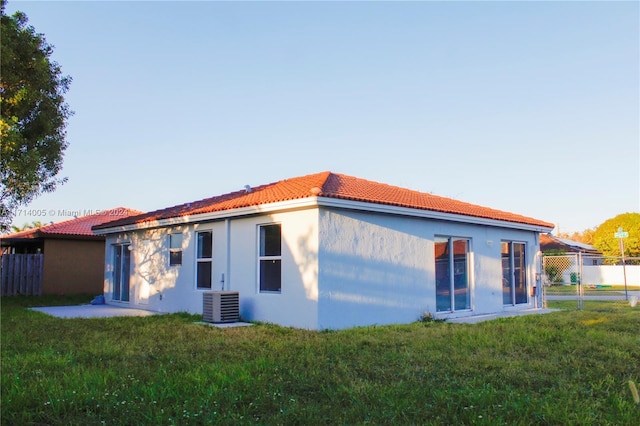 back of house featuring a yard and cooling unit