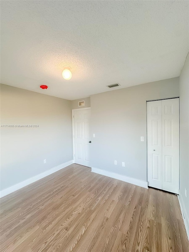 interior space with a textured ceiling and light wood-type flooring