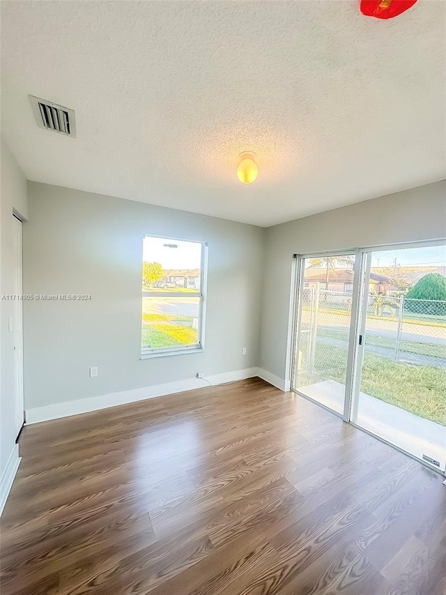 spare room with a textured ceiling and hardwood / wood-style flooring