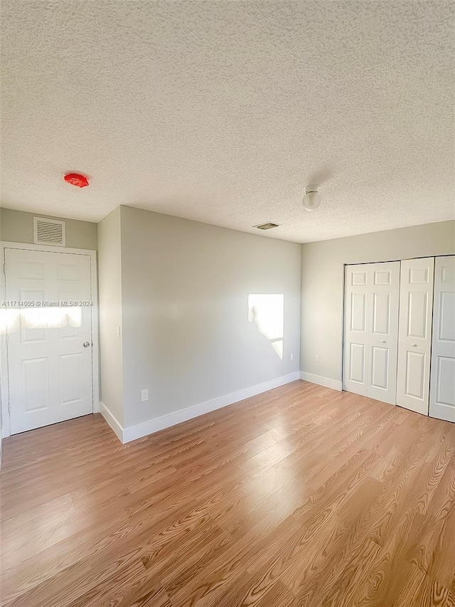 unfurnished bedroom featuring light hardwood / wood-style floors and a textured ceiling