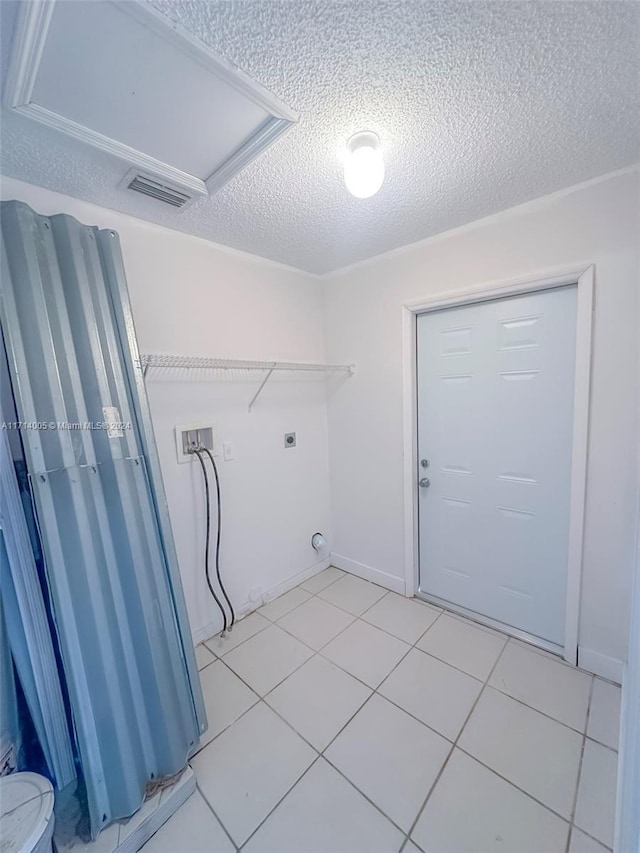 clothes washing area featuring washer hookup, a textured ceiling, light tile patterned floors, and electric dryer hookup