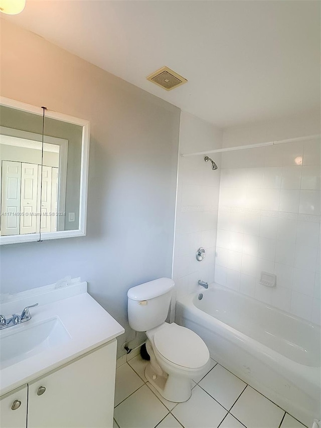 full bathroom featuring tile patterned floors, vanity, tiled shower / bath combo, and toilet