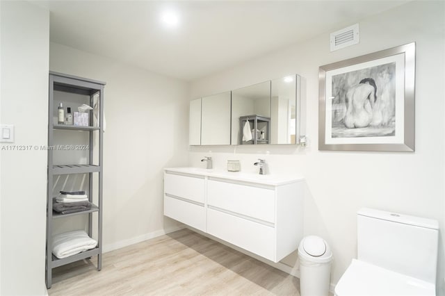 bathroom with vanity, hardwood / wood-style flooring, and toilet