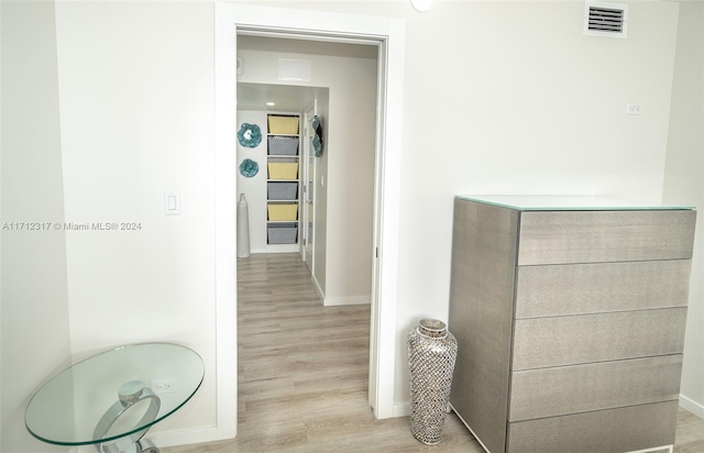 hallway with light hardwood / wood-style floors