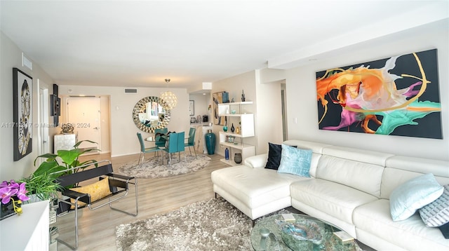 living room with light hardwood / wood-style flooring and a notable chandelier