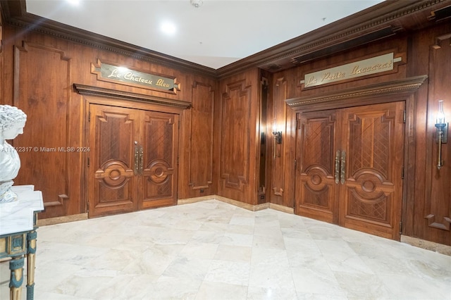 interior space with ornamental molding and wooden walls