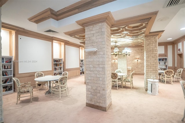 carpeted dining area with ornate columns, ornamental molding, and brick wall