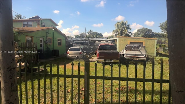 view of gate with a yard and cooling unit