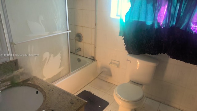 full bathroom featuring tile patterned floors, shower / bath combination with glass door, vanity, and tile walls