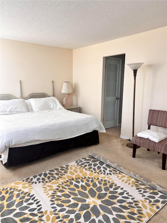 bedroom with carpet and a textured ceiling