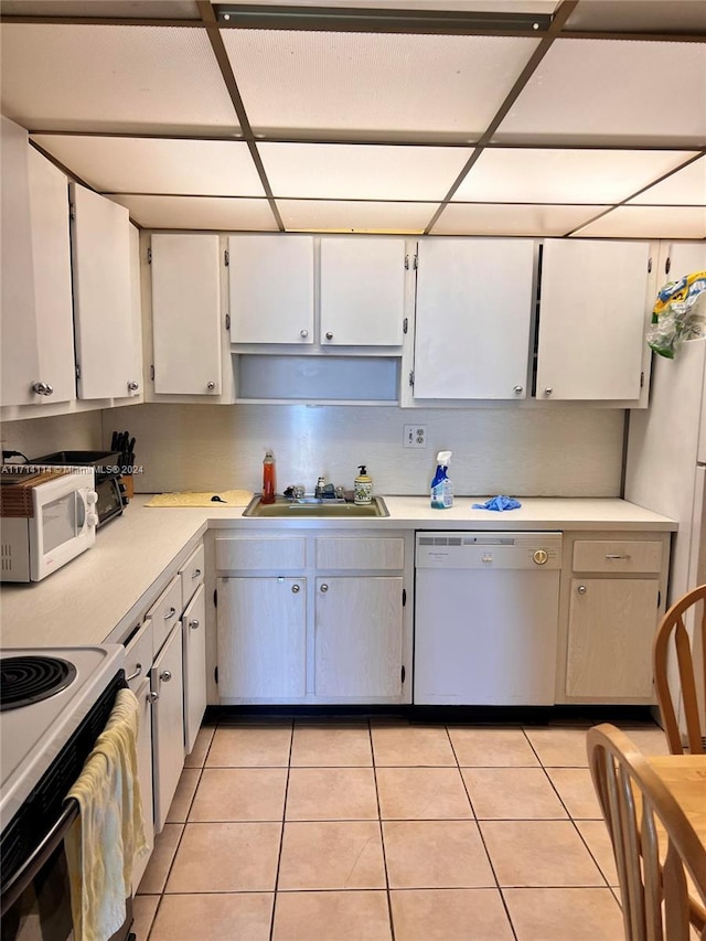 kitchen with white cabinetry, sink, light tile patterned flooring, and white appliances