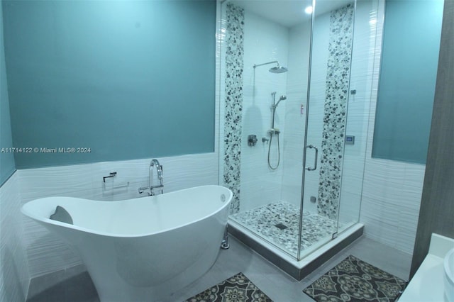 bathroom featuring tile patterned flooring, tile walls, and shower with separate bathtub