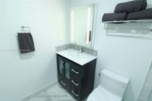 bathroom featuring tile patterned flooring, vanity, toilet, and backsplash