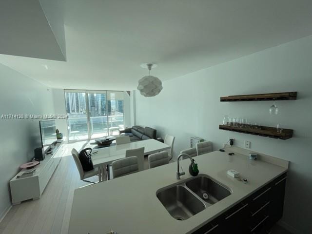 kitchen with sink, expansive windows, and light wood-type flooring