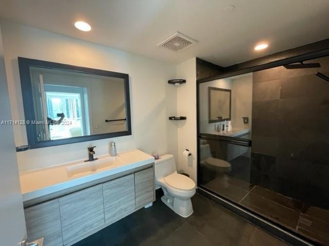 bathroom with vanity, toilet, and a shower with shower door