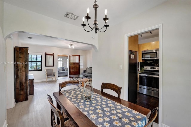 dining area featuring hardwood / wood-style floors and a chandelier