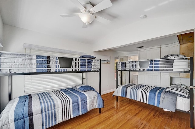 bedroom with ceiling fan, hardwood / wood-style floors, and lofted ceiling