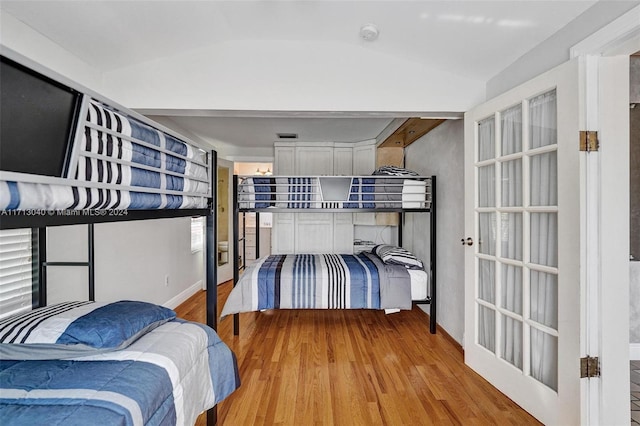 bedroom featuring light hardwood / wood-style flooring and vaulted ceiling