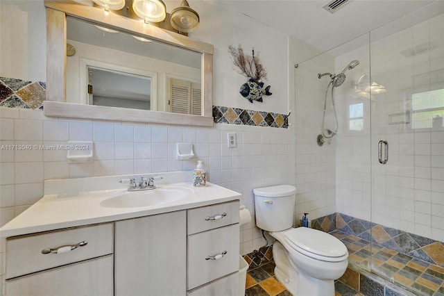 bathroom featuring backsplash, an enclosed shower, toilet, vanity, and tile walls