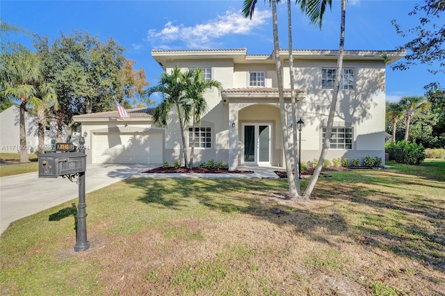 mediterranean / spanish home with a garage, a front yard, and french doors