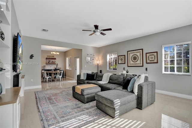 living room with a healthy amount of sunlight and ceiling fan with notable chandelier