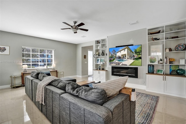 living room with built in shelves and ceiling fan