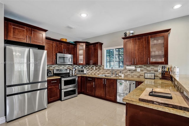 kitchen featuring backsplash, sink, and appliances with stainless steel finishes