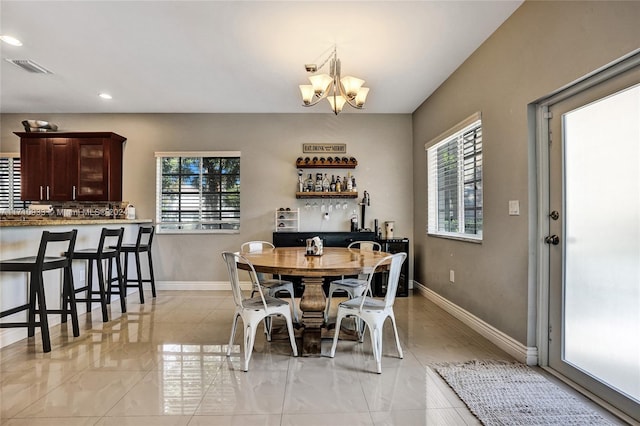 dining space with a chandelier and bar