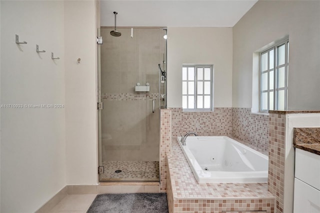 bathroom featuring tile patterned flooring, vanity, and shower with separate bathtub